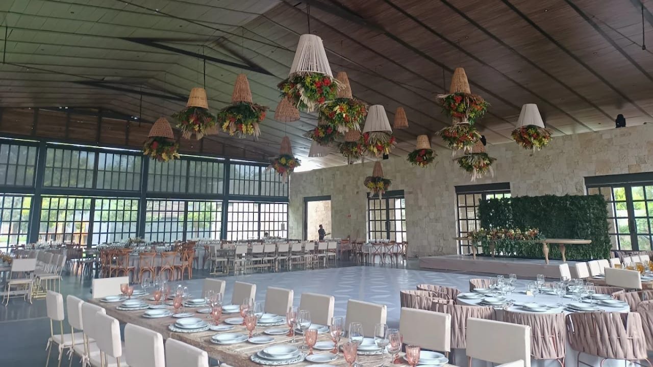 Interior del salón Casalago, con techo de madera y grandes ventanales de piedra