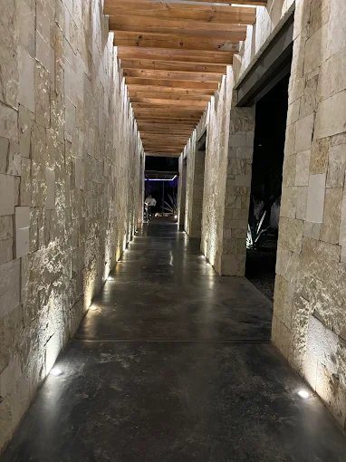 Pasillo de piedra iluminado desde el piso en Casalago